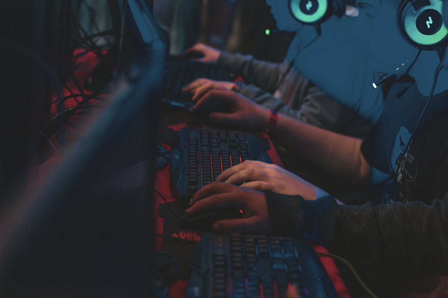 Gamers using backlit keyboards and mice during a tournament.