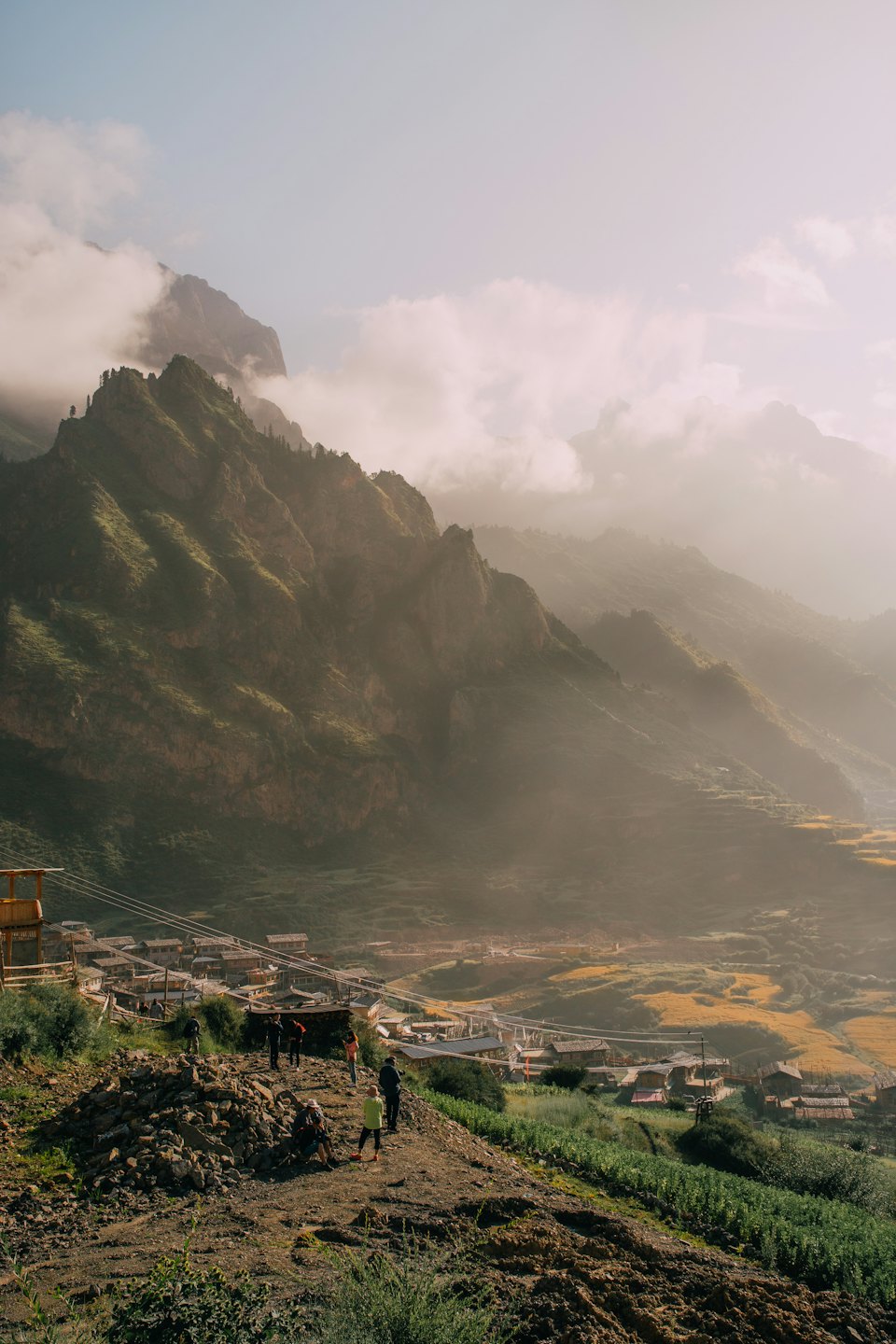 A group observes a village nestled in a mountain valley.